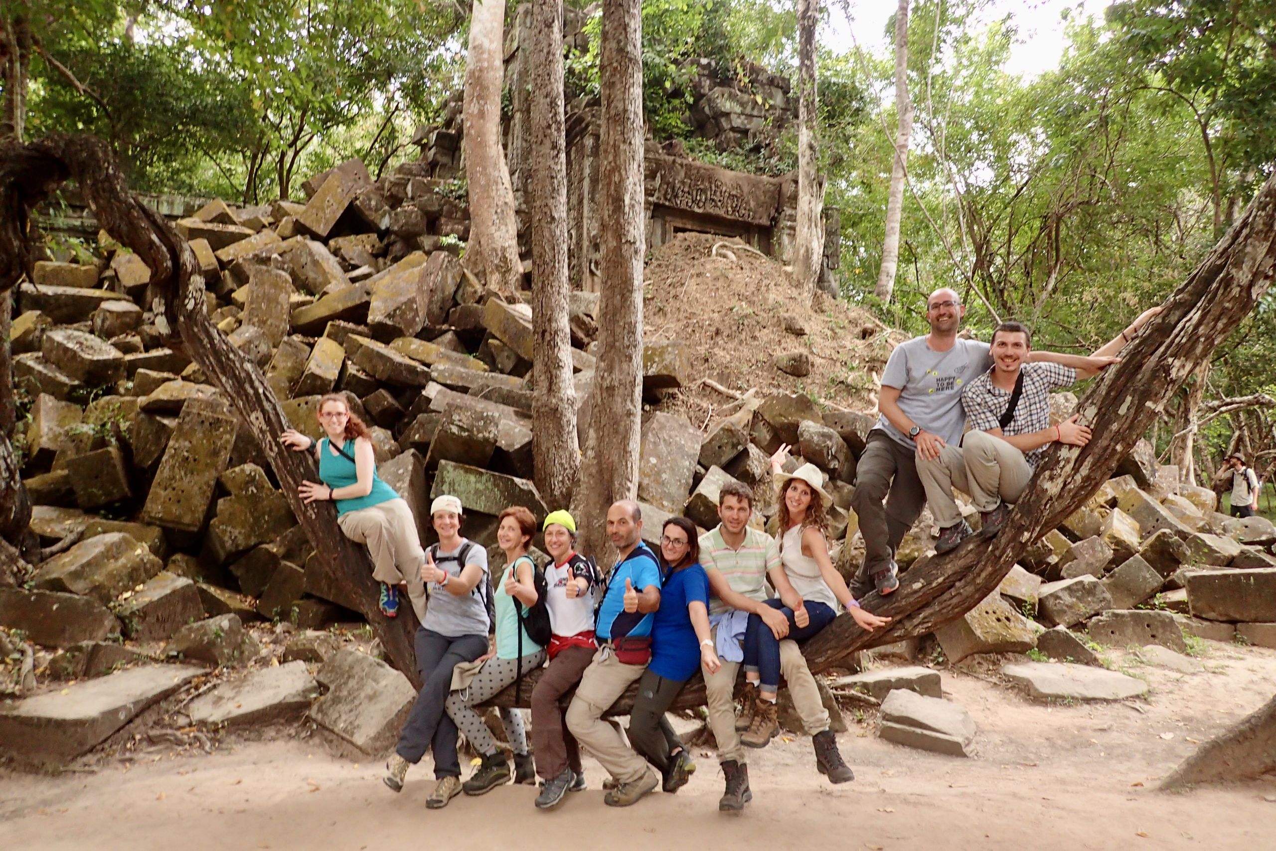Gruppo di viaggiatori Girolibero fra le radici secolari del tempio Ta Prohm, giungla di Angkor, Siem Reap